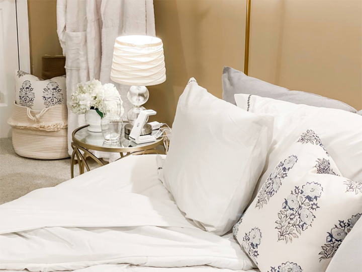 A bed with white linens and a nightstand