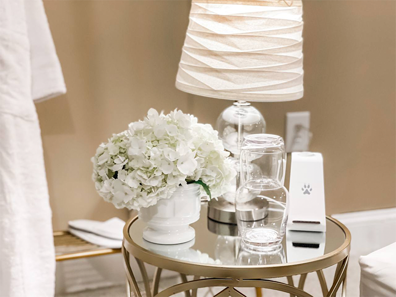 A nightstand with flowers and a glass of water | How to Create a Guest Room When You Don't Have One