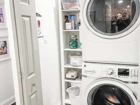 Picture of an organized laundry closet with a stacked washer and dryer