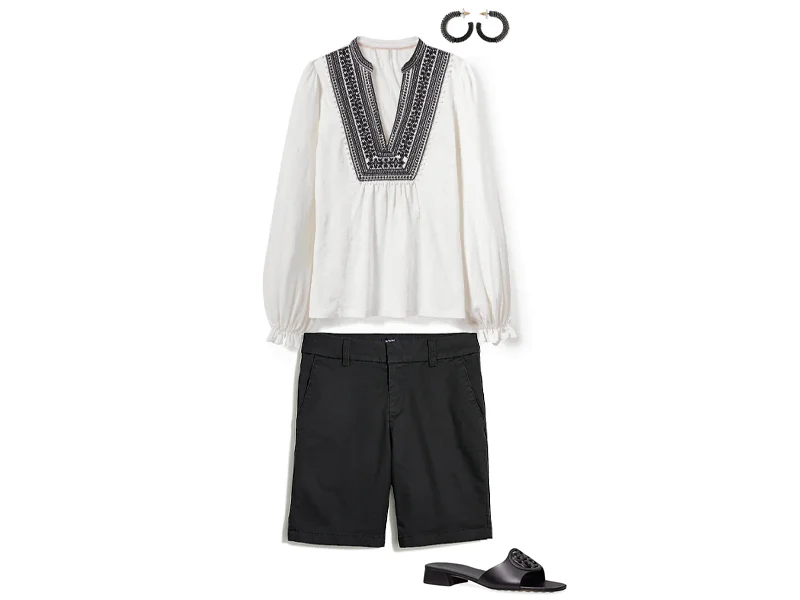 Black bermuda shorts, white embroidered top, black hoops, and black slide sandals