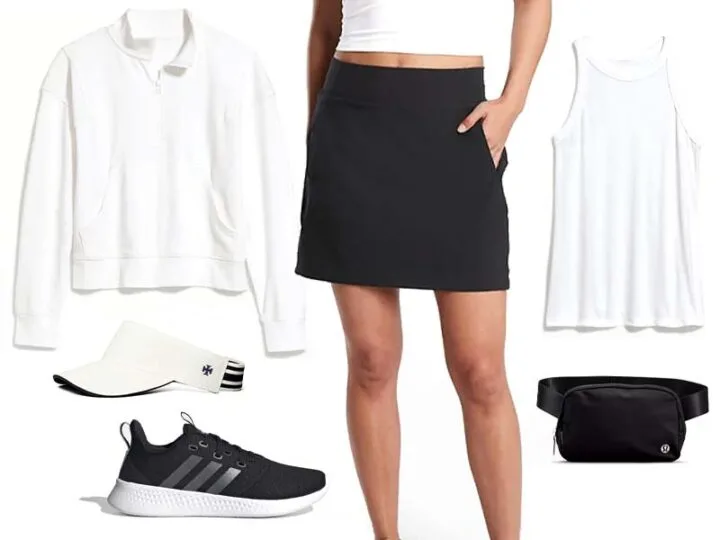 Black Skort with white tank, white half zip sweatshirt, white visor, black sneakers, and black belt bag