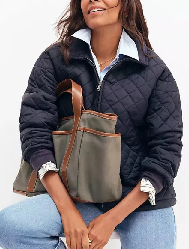 Woman wearing Ann Taylor Weekend Collection Quilted Bomber Jacket in navy, styled with jeans and canvas tote