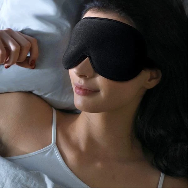 Weighted sleep mask worn while sleeping to block light during travel and overnight flights
