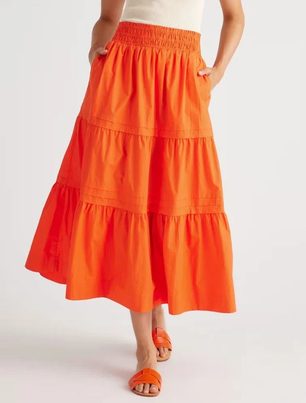 Vermilion red tiered cotton maxi skirt from Quince with smocked waist and pockets, styled for women over 40