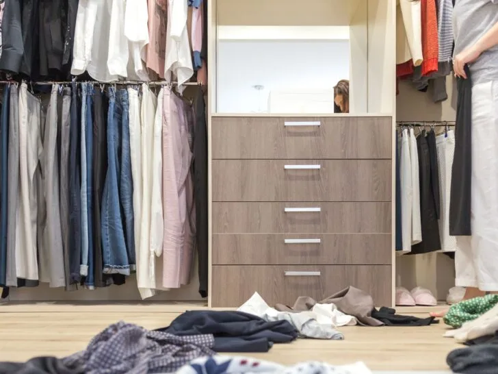 Closet clean-out in progress with clothes sorted on the floor