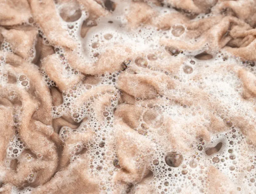 Hand washing a sweater in cold water to gently clean knitwear