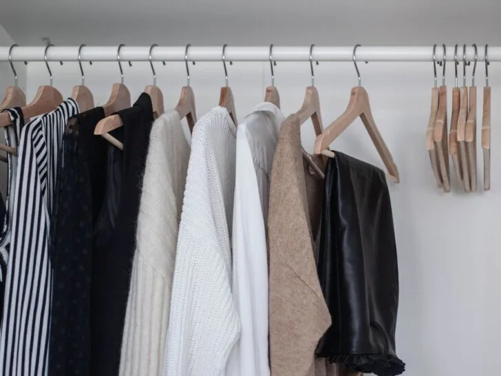 A neutral, edited wardrobe showing essential clothing pieces arranged in a calm, organized closet.