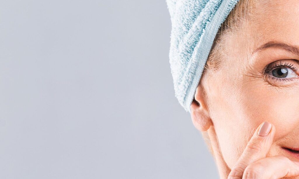 Woman over 40 applying eye cream to reduce crepey under eye skin